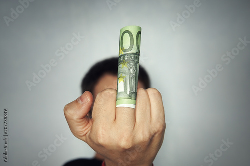 Rude male giving money and showing middle finger. man with the money. To show the middle finger. Brutal angry gesture. Rude, sarcastic. To give or take bribe, the bribe taker, official, dishonest photo