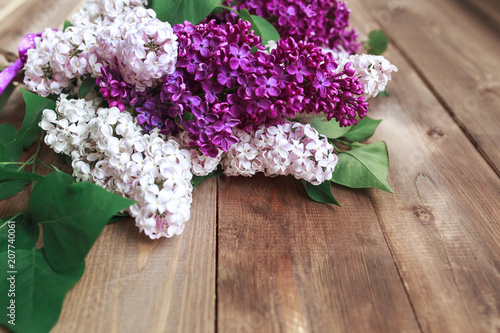 Bouquet of purple lilacs flowers on a brown wooden background