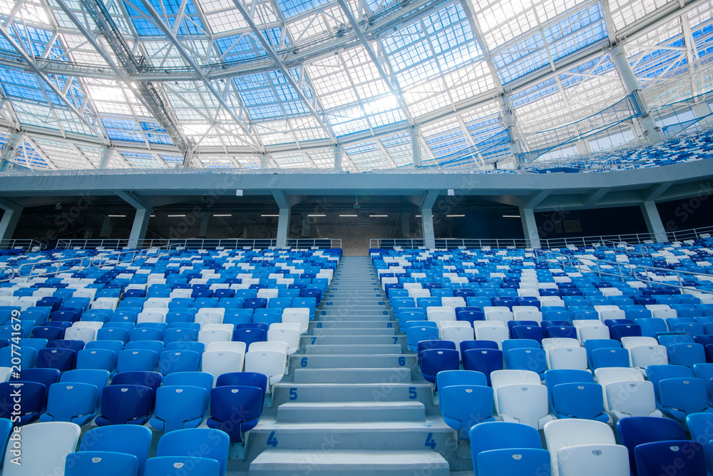 Naklejka premium Cement stairs and blue seats inside football stadium