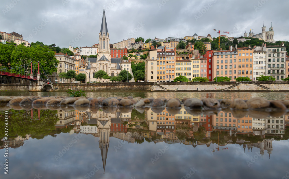 The historical buildings of UNESCO world heritage site Vieux-Lyon reflected in a puddle. Lyon, France.