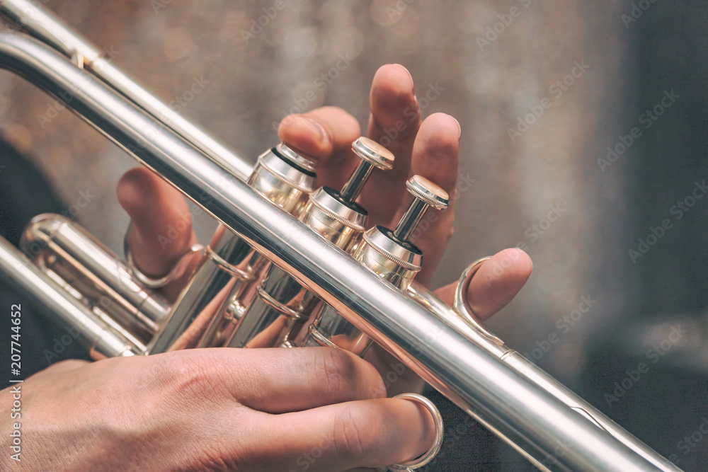 Obraz premium Hand of the Trumpeter on the buttons of trumpet