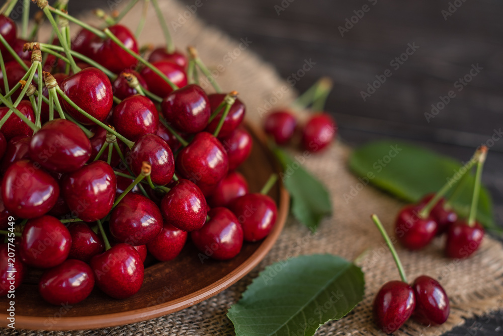 Tasty juicy sweet cherry on a wooden background. It can be used as a background Tasty juicy sweet cherry on a wooden background. It can be used as a background