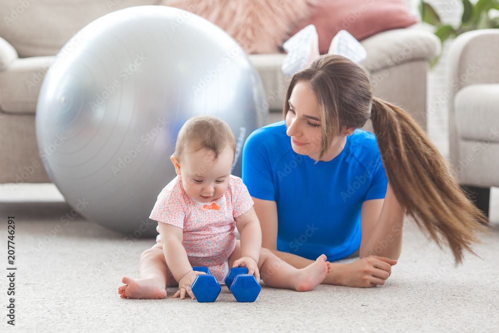 Young pretty mother working out with her little child at home Young pretty mother working out with her little child at home