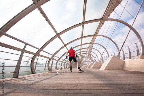 A young man cross-country skiing with roller ski photo