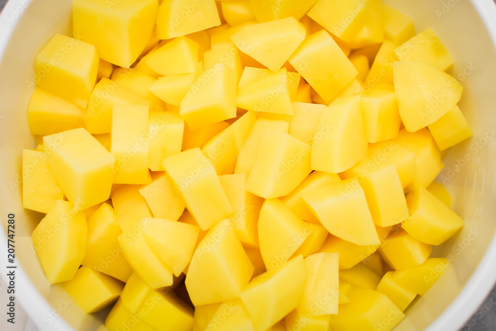 close up Sliced, peeled raw potatoes in a white bowl, top view close up Sliced, peeled raw potatoes in a white bowl, top view