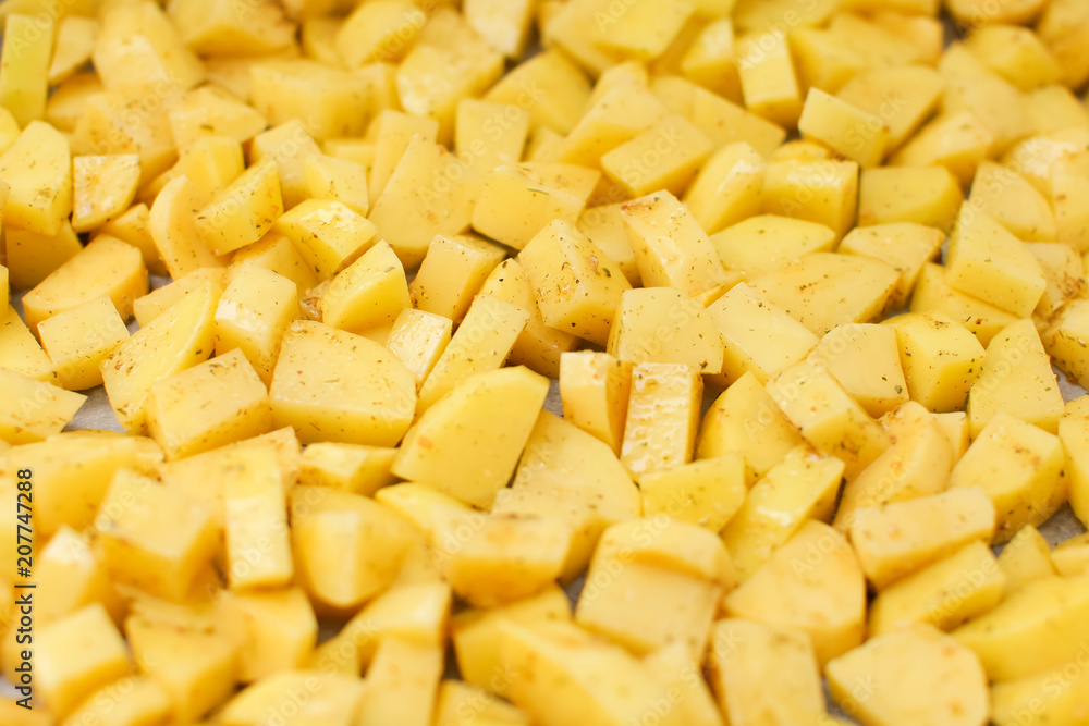 close up cut potatoes with seasoning on a tray in selective focus close up cut potatoes with seasoning on a tray in selective focus