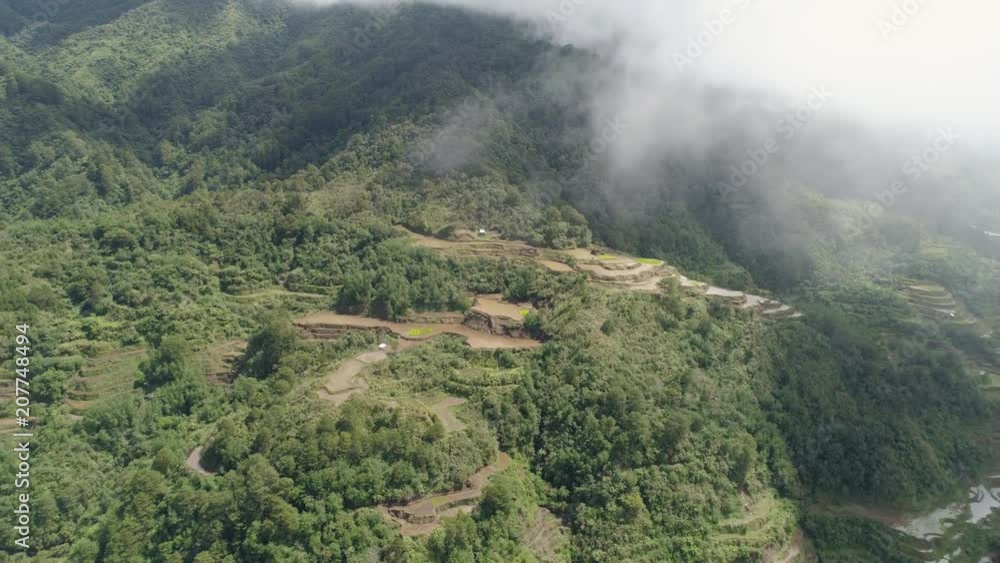 Aerial view of rice terraces on the slopes of the mountains, Banaue, Philippines. Rice cultivation in the North Batad. Mountains covered forest, trees. Philippine Cordilleras. Aerial view of rice terraces on the slopes of the mountains, Banaue, Philippines. Rice cultivation in the North Batad. Mountains covered forest, trees. Philippine Cordilleras.