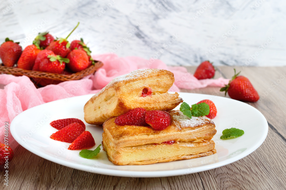 Sweet tasty puff pastry dessert on a plate on a wooden background. Delicious homemade cookies with strawberry jam, berries and sugar powder Sweet tasty puff pastry dessert on a plate on a wooden background. Delicious homemade cookies with strawberry jam, berries and sugar powder