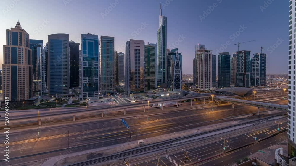 Aerial view of Jumeirah lakes towers skyscrapers night to day timelapse with traffic on sheikh zayed road. Aerial view of Jumeirah lakes towers skyscrapers night to day timelapse with traffic on sheikh zayed road.