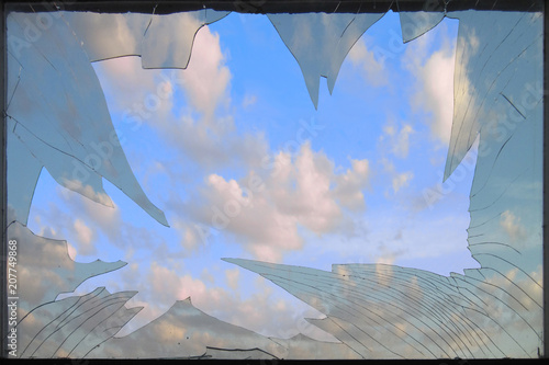 reach out to heaven. Clouds in the sunset light visible through the dirty broken window