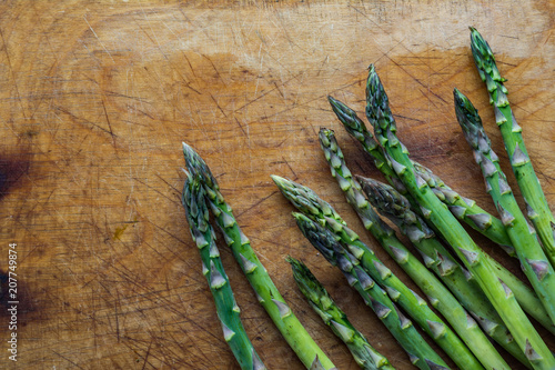 Fresh green asparagus on wooden background photo