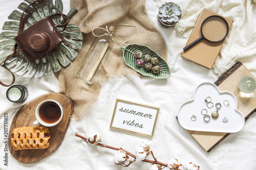 Trendy flat lay of workplace with card, woman accessories and retro photo camera. Lifestyle blogg concept.