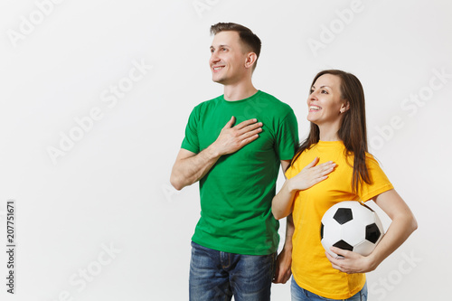 Foto Emotional couple, woman man, football fans in yellow green t-shirt cheer up support team with soccer ball singing national country anthem isolated on white background