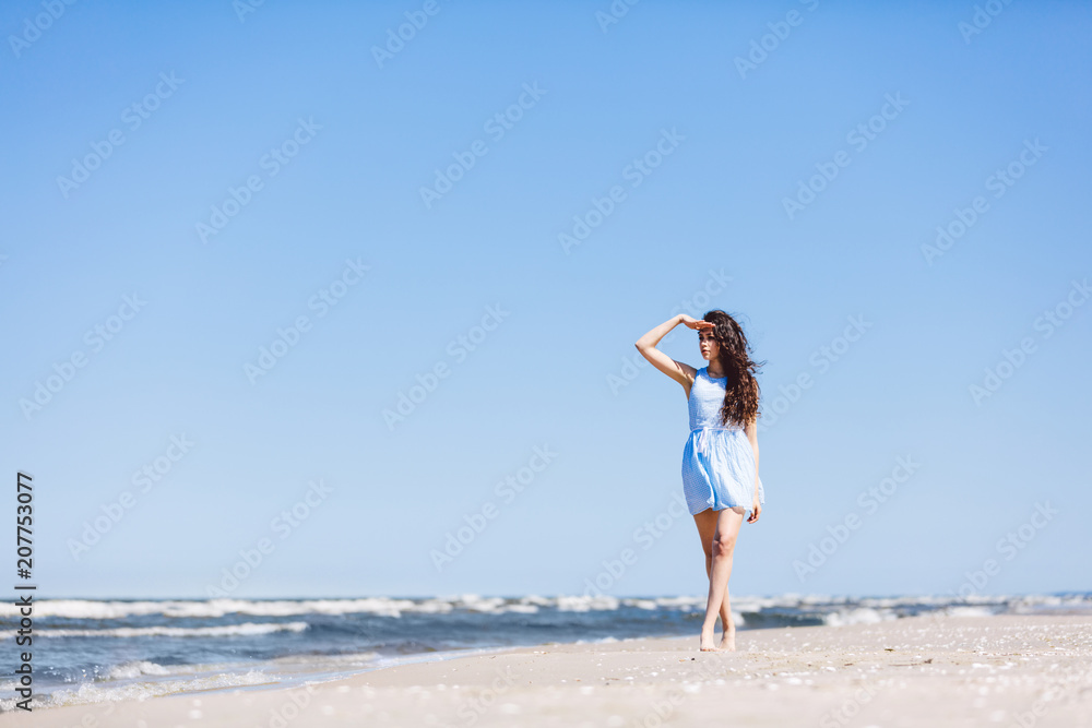 A young girl looking steadily at the sea.