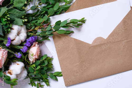 Mockup with postcard, flowers bouquet, kraft envelope. photo