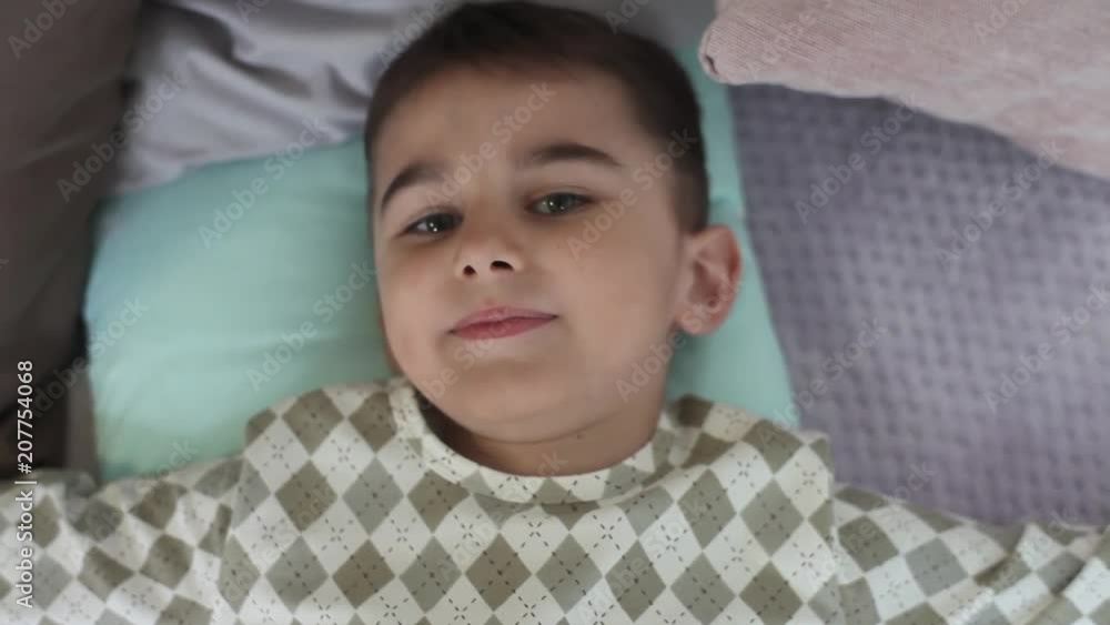 Little boy in pajamas falls on a pillow Little boy in pajamas falls on a pillow