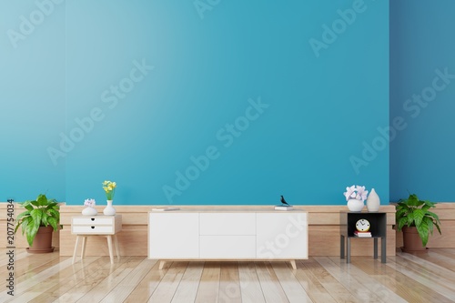 TV cabinet in modern living room with table,flower and plant on blue wall background,3d rendering