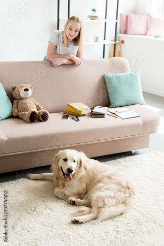 Fototapeta Naklejka Na Ścianę i Meble -  happy teen girl spending time at home with her dog