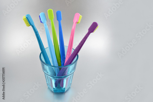 Colored toothbrushes stock images. Morning hygiene. Bathroom accessories images. Toothbrush on a gray background. Toothbrush on a silver background with copy space for text
