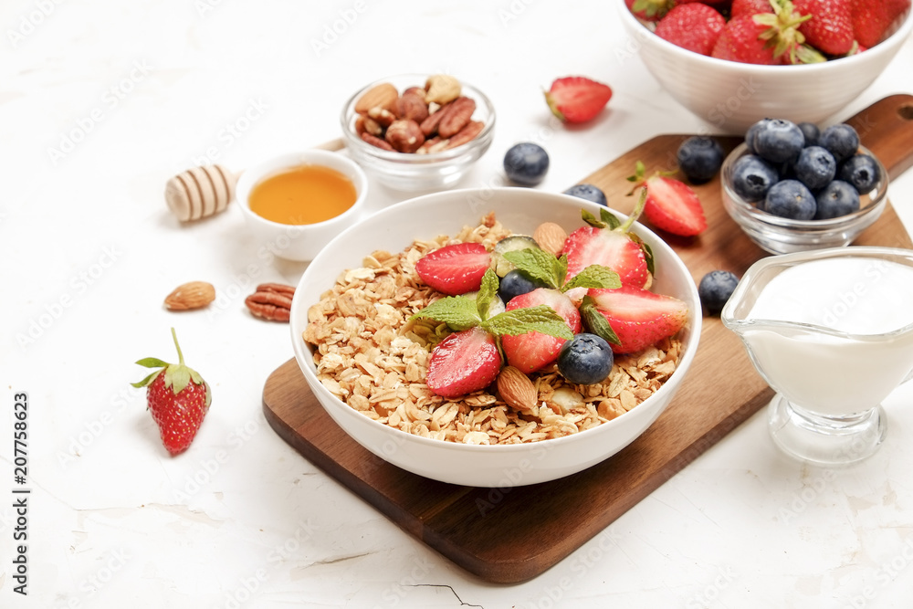 Serving option of granola bowl with mix of nuts, cereals, fruits and berries, greek yogurt. Healthy vegetarian breakfast, organic strawberry, blueberry, mint, almond. Close up, top view, background. Serving option of granola bowl with mix of nuts, cereals, fruits and berries, greek yogurt. Healthy vegetarian breakfast, organic strawberry, blueberry, mint, almond. Close up, top view, background.