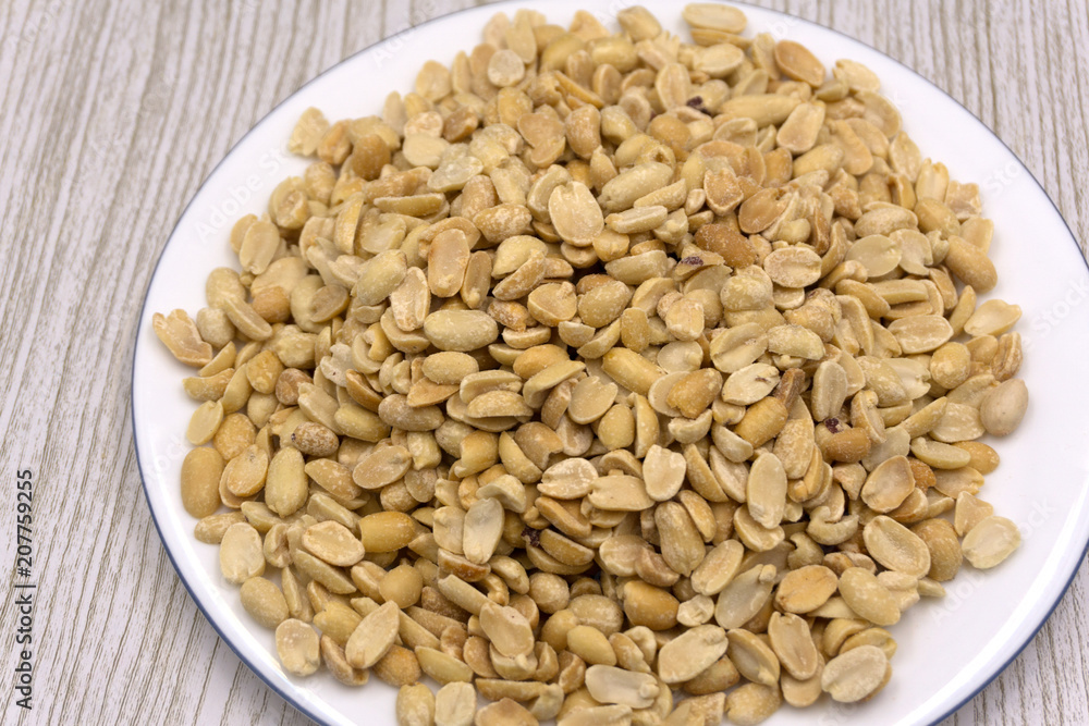 Roasted peanuts, salt, put in a cup. Brown was placed on the wooden floor.