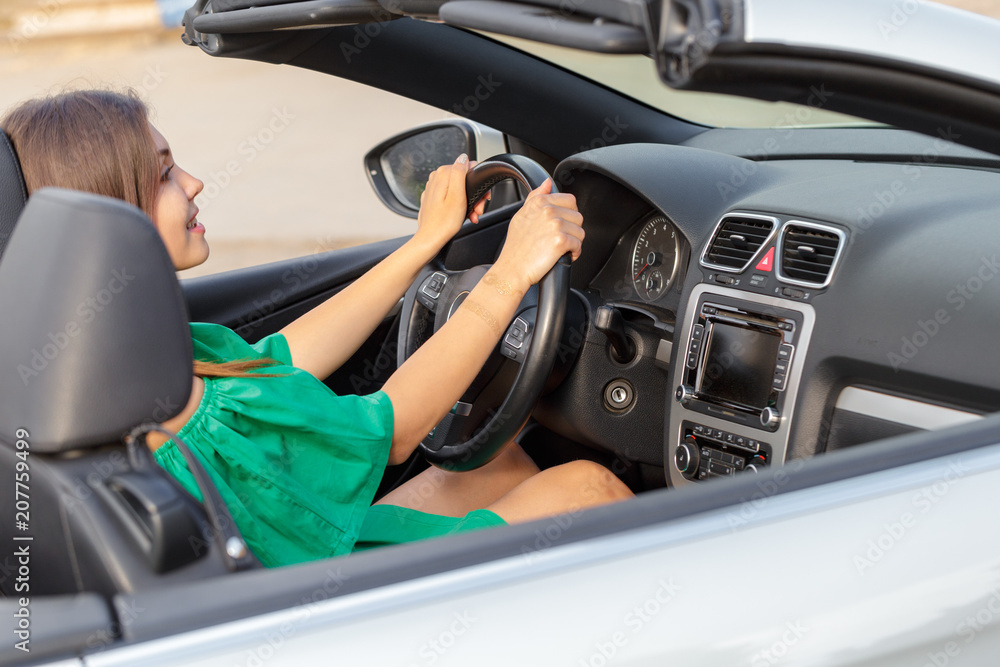 Young woman driving a car in the city. Young woman driving a car in the city.