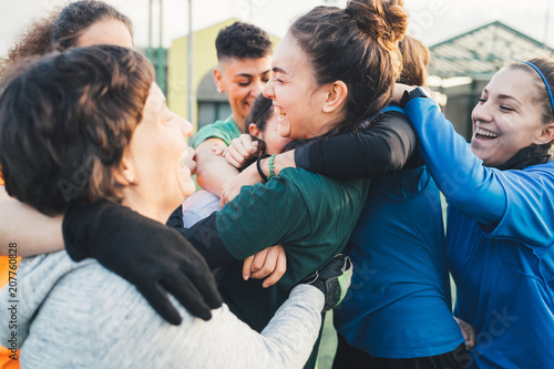 Football players jubilant and hugging on pitch