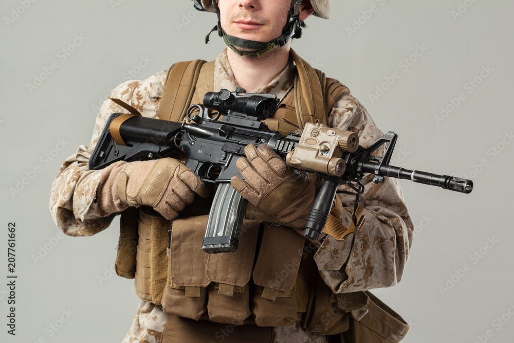 Soldier in camouflage holding rifle Soldier in camouflage holding rifle