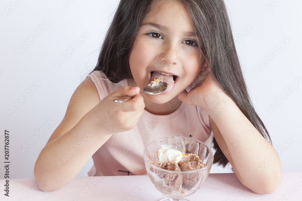 Happy child girl eating ice cream in white and chocolate bowl on white background. Enjoying delicious. Happy child girl eating ice cream in white and chocolate bowl on white background. Enjoying delicious.