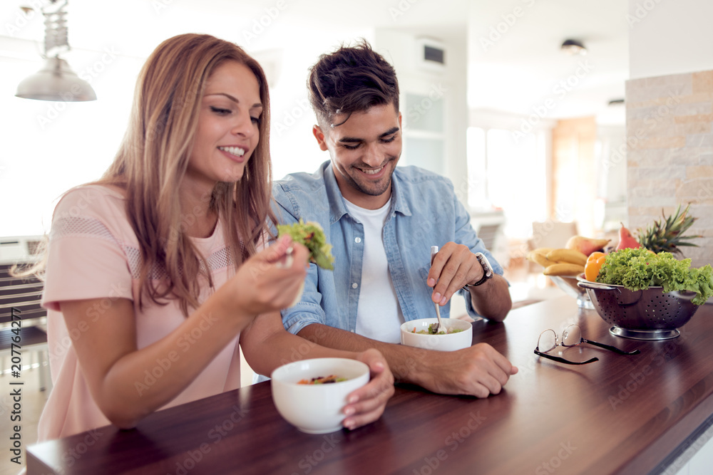 Couple eating a salad in the kitchen