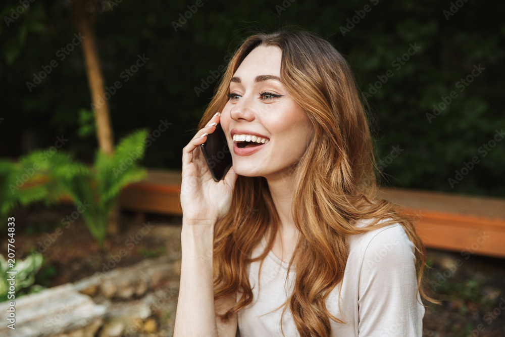 Close up of smiling young girl talking on mobile phone Close up of smiling young girl talking on mobile phone