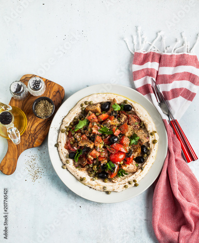 fresh Greek dakos salad on a layer of hummus. light vegan summer nutritious recipe photo