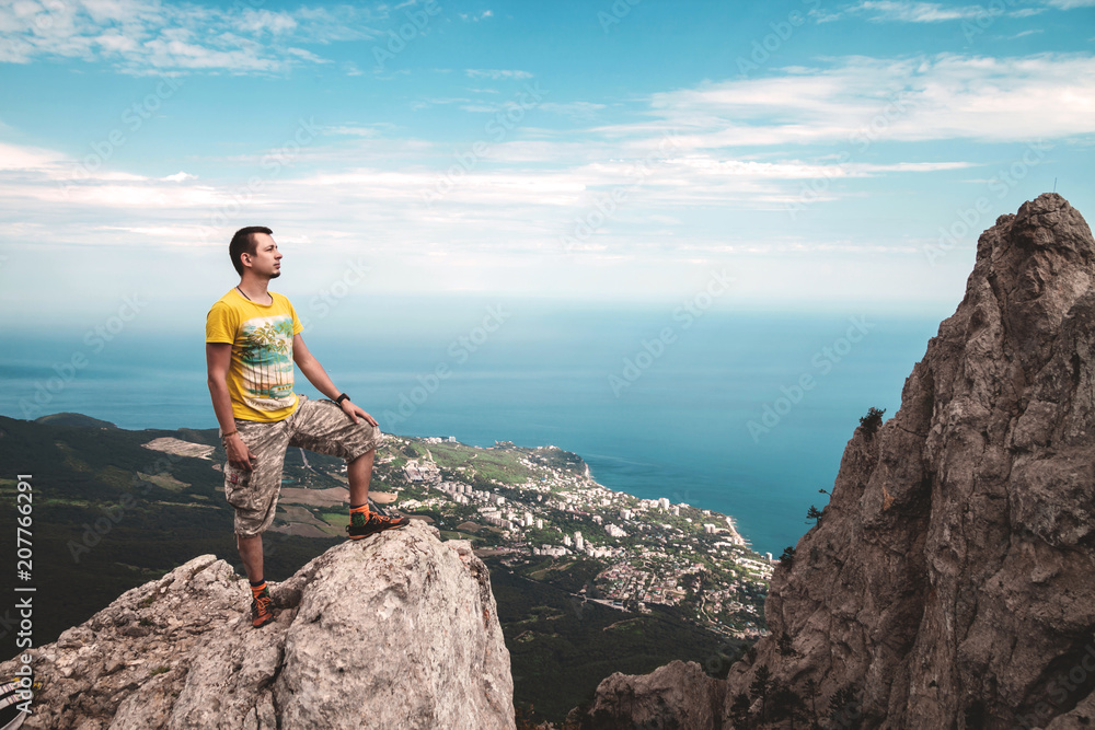 Man standing on the cliff in the mountain near the sea, Ai-Petri Man standing on the cliff in the mountain near the sea, Ai-Petri