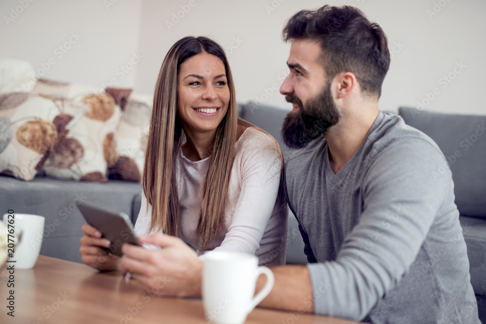 Cheerful couple using digital tablet at home Cheerful couple using digital tablet at home
