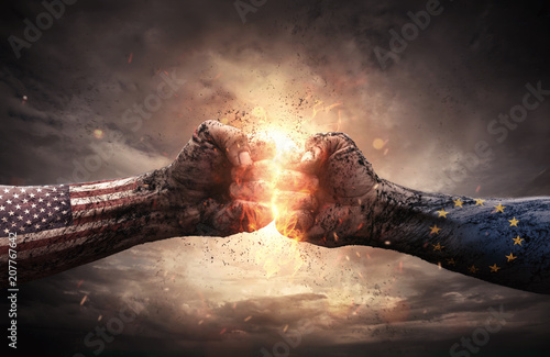 USA- UE embargo conflict, close up of two fists hitting each other over dramatic sky background with copy space