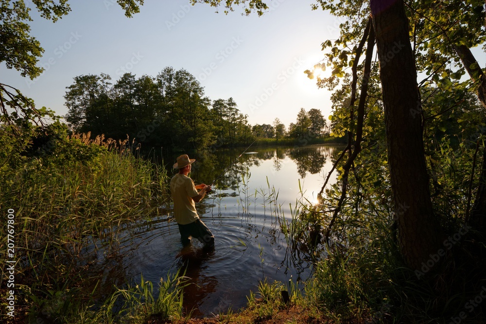 Fisherman in the lake during sunny day