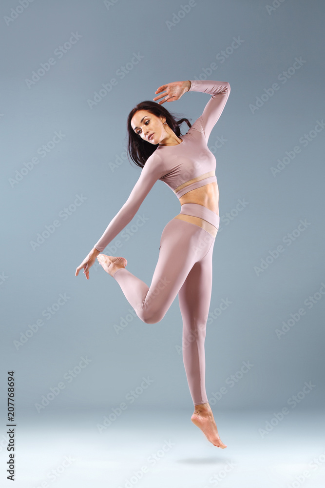 custom made wallpaper toronto digitalAttractive excited fitness girl, ballerina dancer in sportwear jumping of joy isolated over gray background.