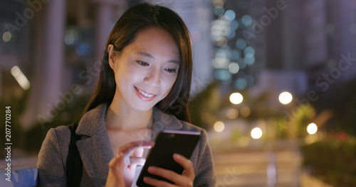 Business woman working on smart phone at night