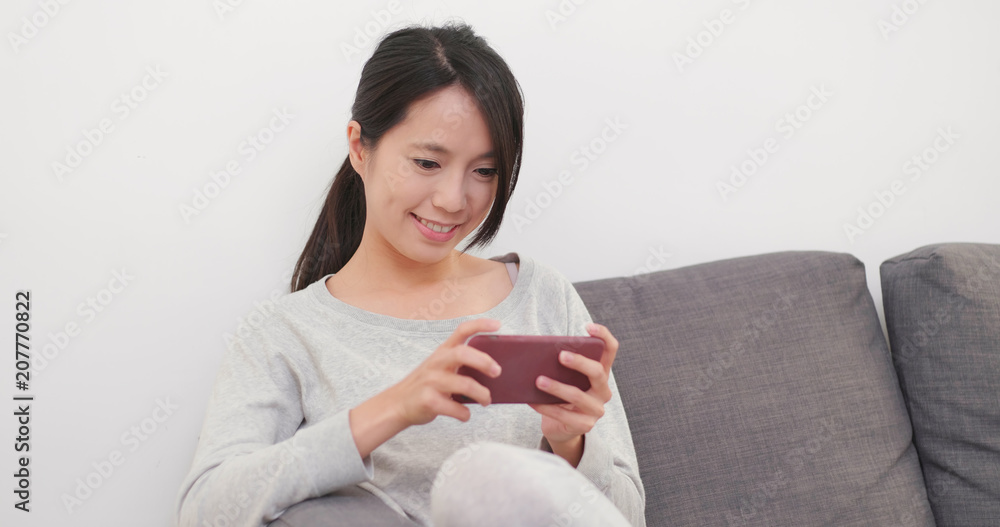 Woman using mobile phone and sitting on sofa Woman using mobile phone and sitting on sofa