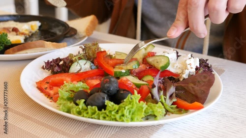 Wallpaper Mural Young man in restaurant eating healthy food vegetable salad during breakfast Torontodigital.ca