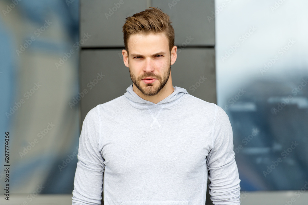 Metrosexual concept. Guy bearded and attractive cares about appearance. Man  with bristle on serious face, urban background, defocused. Man with beard  or unshaven guy looks handsome and cool Stock Photo