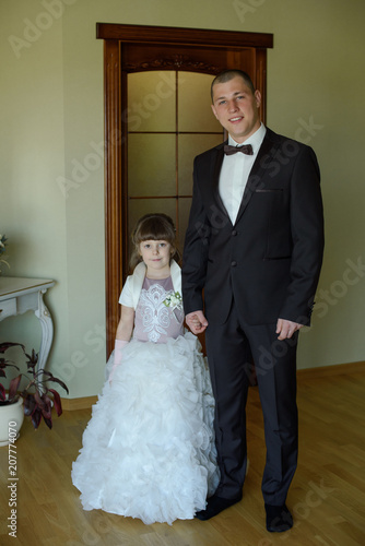 Little child girl bride in white dress and groom