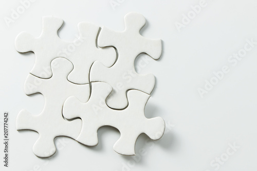 Four pieces of blank white jigsaw puzzle isolated on white background for business conceptual photo