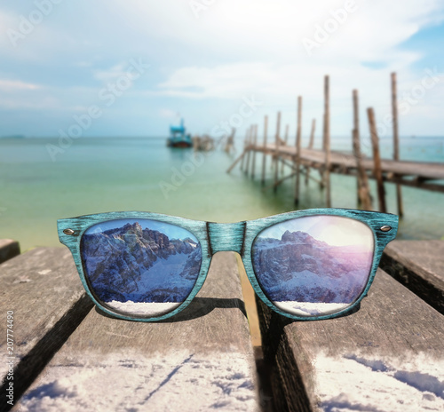 Summer winter contrast mirroring in sunglasses at the beach