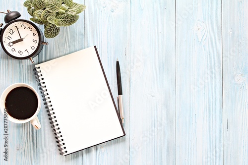 Still life, business, planning or working concept : Open notebook with blank pages, coffee cup and clock on wooden desk table, top view or flat lay with copy space ready for adding or mock up