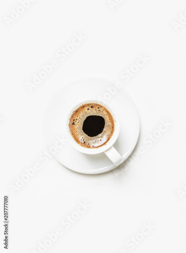 White cup of black coffee espresso with foam, white background, top view