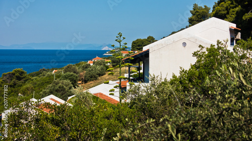 Viewpoint from white appartment houses surrounded by greenery at the coast of Skopelos island near Panormos bay in Greece