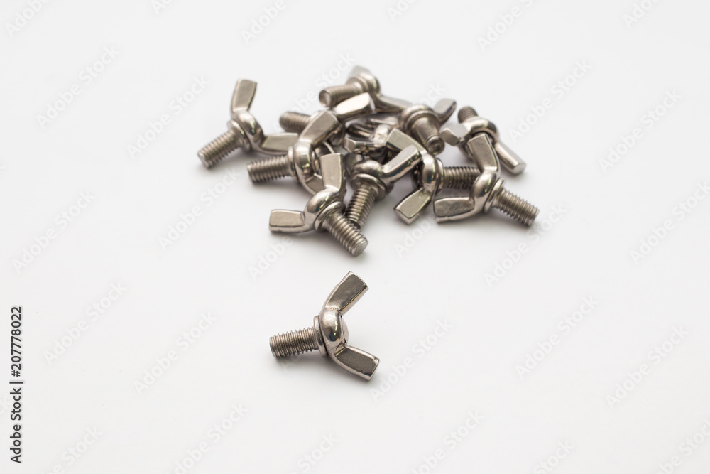 Hardware parts stainless steel winged screw bolts on white background. Hardware parts stainless steel winged screw bolts on white background.