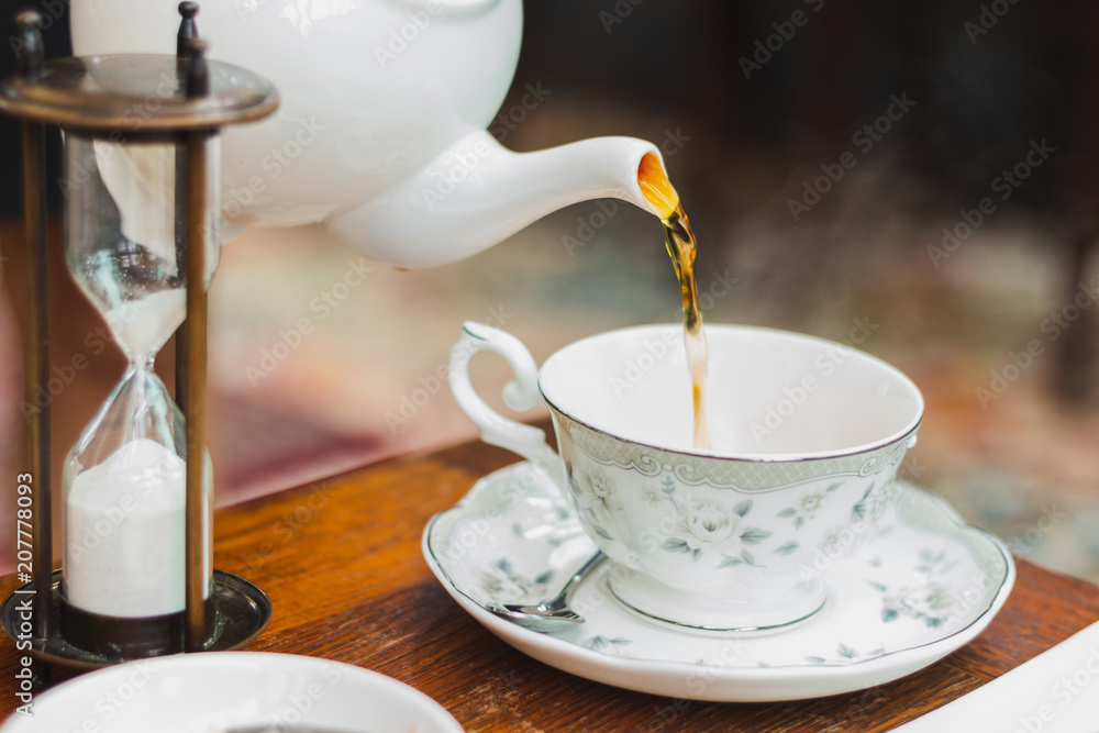 White Tea Pot And Cup With Tea Strainer On Wooden Table, Relaxing With Hot  Tea During Tea Break. Stock Photo, Picture and Royalty Free Image. Image  84607717.