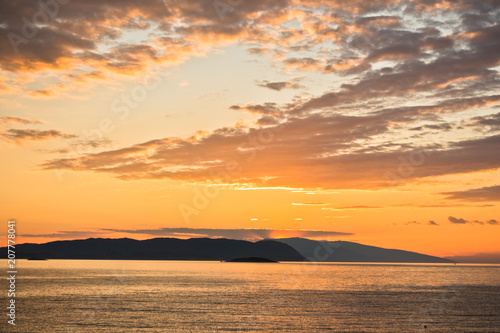 Sun is setting behind Skiathos island  view from Kastani Mamma Mia beach  island of Skopelos  Greece